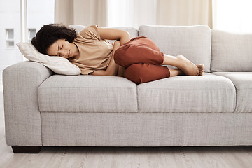 Image showing Black woman, stomach pain and digestion with constipation, problem and endometriosis on the sofa in home. Young female, sick and abdomen cramp and diarrhea with ibs, menstrual cycle and bowel ache