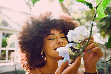 Image showing Woman, smell flowers and spring garden enviroment for plants wellness or sustainability. African person, green energy and smelling floral fragrance or gardening, ecology and happiness in nature