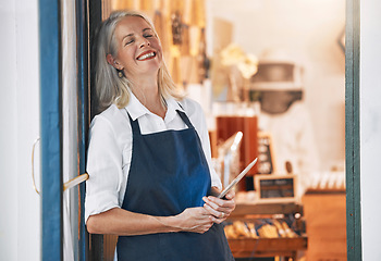 Image showing Happy senior business owner with a tablet in her store for startup with technology or mobile device. Leader, entrepreneur and elderly woman standing by an open door to welcome customers in the shop.