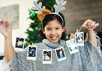 Image showing Christmas, celebration and girl with polaroid for decoration, happy and show photos in the house. Smile, excited and portrait of a child with pictures to decorate the home for a festive xmas