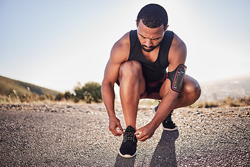 Image showing Fitness, tie and shoes of a man on a road for running, cardio workout or training for a marathon in summer. Focus, wellness and healthy sports athlete runner tying footwear laces to start exercise
