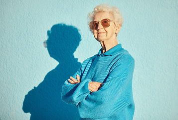 Image showing Fashion, sunglasses and portrait of old woman with arms crossed on wall background for stylish, cool and unique aesthetic. Retirement, beauty and elderly female model with designer brand glasses.