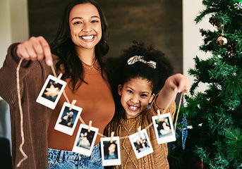 Image showing Christmas, decoration and mother and girl with Polaroid on a tree for love, happiness and celebration of holiday in a house. Festive, happy and portrait of a mom and child show picture for decorating