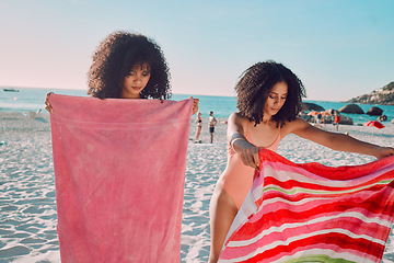 Image showing Woman, friends and beach towel for relaxing on the sand during summer break or vacation together in the outdoors. African American female women opening towels to relax on the sandy ocean coast