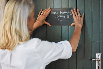 Image showing Hands, sign and beekeeping with a woman farmer hanging a note on her door before leaving to go farm. Wood, agriculture and small business with a female beekeeper outdoor for the production of honey