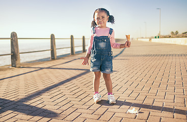 Image showing Upset little girl, ice cream and sad in Cape Town with expression in frustration for a spoilt day by the ocean bay. Unhappy moody child holding empty icecream cone melting mess on floor at sea point
