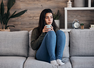 Image showing Depression, sad and woman with coffee on a sofa for thinking, lonely and isolated in a living room. Stress, anxiety and girl drinking tea on couch, looking depressed about debt or mental health