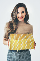 Image showing Gift, woman and present for celebration, christmas or birthday on a studio background for happiness, giving and kindness. Portrait of a model with gift box to celebrate surprise holiday mockup