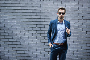 Image showing Travel, work and cool businessman in city for business, meeting or development, confident and proud against brick wall background. Boss, man and New York business travel by entrepreneur with a vision