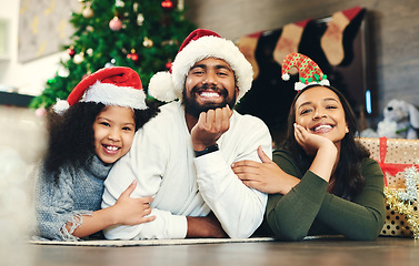 Image showing Christmas, portrait and family, kids and parents in lounge, winter celebration and love, care and happiness together. Happy family, girl and child celebrate festive holiday, santa hats or living room