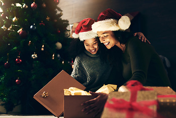 Image showing Night, mother and child with a gift for Christmas in celebration of a happy family holiday in winter at home. Love, giving and exited mom opening a present box with girl kid to celebrate festive time