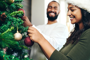 Image showing Christmas, love and couple decorating Christmas tree together for holiday, festival celebration and vacation. Bonding, marriage and happy man and woman decorate tree for festive tradition at home