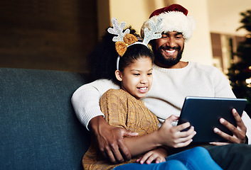 Image showing Family Christmas, tablet and girl with father on sofa in living room streaming video, movie or web browsing. Love, xmas and kid with dad on digital touchscreen bonding, caring and enjoying holiday.