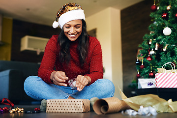 Image showing Woman, wrapping gift for Christmas with tape and gift box, holiday celebration and happiness. Happy woman on living room floor, present with ribbon and paper, smile and celebrate in family home.