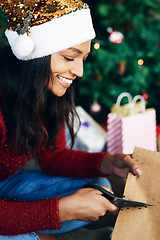 Image showing Christmas, woman and scissors for cutting paper to wrap gift in home. Xmas spirit, holiday and happy female from India with clippers to cut wrapping paper for packing gifts or presents in house alone