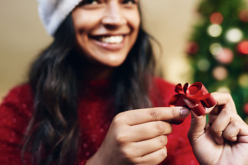 Image showing Christmas, ribbon and woman wrapping gifts for a holiday party, event or dinner at home. Happy, excited and girl with a smile holding bow for festive decoration for xmas celebration presents at house