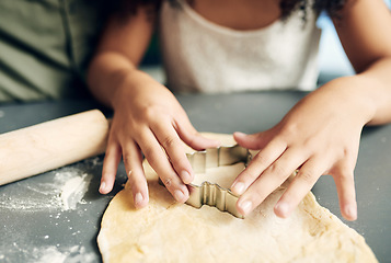 Image showing Family, hands baking and christmas tree cookies being made with a cutter while bonding and learning. Sweets, dessert and biscuit treat being baked with dough by a child and her parent at xmas