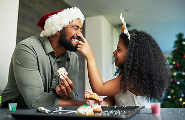 Image showing Christmas, father and kid with cookie, food fight and playful, celebrate and holiday fun at home. Happy family, man with girl and love, baker dessert and celebration, happiness and xmas at home.