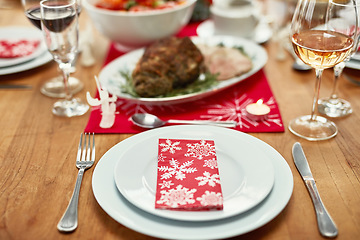 Image showing Wine glass, plate and cutlery on the table at a christmas party or event in the dining room of a house. Napkin, table setting and dinner party for a festive xmas holiday lunch celebration at a home.