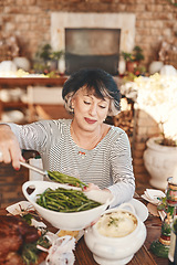 Image showing Thanksgiving table and senior woman with vegetables serving at food party for USA celebration. Holiday, celebrate and mature festive person at home dining table with green beans for nutrition.