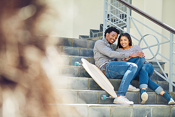 Image showing Couple, happy and skateboard while sitting on stairs with hug, love and romance in city sunshine. Black couple, urban happiness and outdoor with skater, embrace and romance on steps in San Francisco