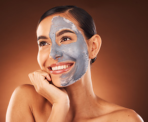 Image showing Face, beauty skincare and woman with clay mask in studio isolated on a brown background. Makeup, aesthetics and happy female from Canada thinking about healthy and glowing skin after facial treatment