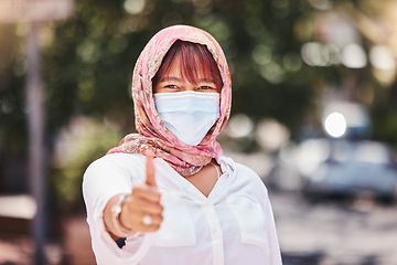 Image showing Success, hijab and woman thumbs up with covid protection on Turkey, Europe holiday walk in town. Yes, agreement and vacation of muslim travel person walking with face mask for corona safety.