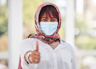 Image showing Thumbs up, Islamic woman and mask for covid protection, vaccine and health outdoor. Muslim female, hand gesture or healthy lady with face cover, corona and safety regulations for virus and infection.