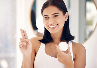 Image showing Face, beauty and skincare with a woman in the bathroom of her home to promote a cosmetic product. Portrait, antiaging and treatment with an attractive young female applying lotion to her skin