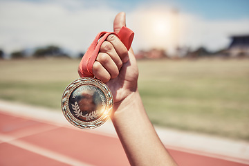 Image showing Closeup, hand and medal for winning, success on track for marathon for wellness, outdoor and sports. Victory, athlete and winner holding gold award, achievement and competition for goal and champion.