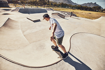 Image showing Skater, sports and man at skate park in city performing action trick or stunt. Fitness, skateboarding and young male skateboarder on ramp training, practice or workout outdoors in town for exercise.