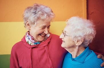 Image showing Friends, happy and retirement with a senior woman and friend outdoor together on a color wall background. Smile, freedom and glasses with mature female friendship bonding or laughing outside