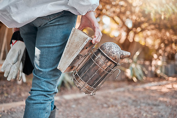 Image showing Beekeeper, farm and bee bellows while outdoor in nature with ppe, gloves or safety in apiculture. Beekeeping farmer, agriculture or insect farming for honey production in sustainable countryside