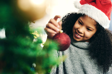 Image showing Christmas, tree and girl with ornament, happy and celebration for holiday, smile and content. Xmas, black kid and female child with decorations for festive season, happiness and cheerful for vacation