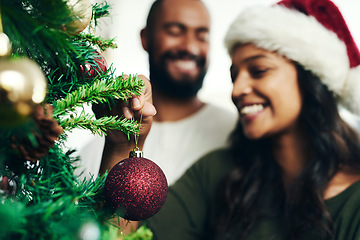 Image showing Christmas, decorating tree and happy black couple celebrate holiday season with love, happiness and festive bonding. Black woman, man smile together and enjoy decorate Christmas tree in living room