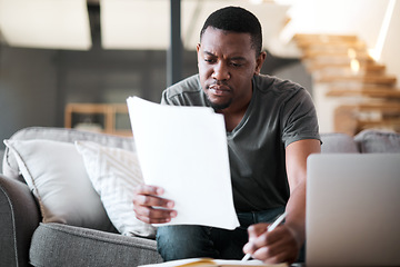 Image showing Remote work, living room and black man with paperwork for insurance, investment of home financial. Man reading budget, taxes and documents on a lounge sofa writing document research for online job