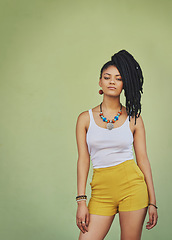 Image showing Portrait of black woman, urban fashion and model posing on green wall of studio background for trendy African style, jewelry and women clothing. Cool model attitude, dreadlocks girl and natural hair