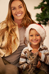 Image showing Portrait of family on Christmas, child with cat and mother on festive holiday together in Dallas home. Happy mom giving kitten as gift to kid, celebration of love with pet or relax by christmas tree