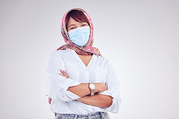 Image showing Covid, Muslim and portrait of woman with mask in white background studio for safety and virus protection. Healthcare, covid 19 and Islamic female with face mask, hijab and crossed arms in pandemic