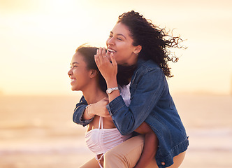 Image showing Woman, friends and piggy back on beach for happy sunset travel vacation or summer holiday. Couple, friendship and relax quality time or playful bonding together on ocean sand for love or happiness