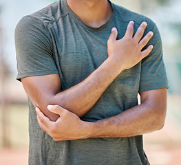 Image showing Sports, man and elbow injury during exercise, training and cardio against blurred background mockup. Arm pain, injured and heart attack sign by athlete running in city for marathon, practice and run