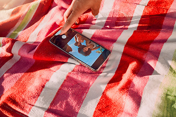 Image showing Hand, phone and selfie by friends at a beach for travel, fun and picture on towel, finger and screen. Women, hands and social media influencer set timer for recording, content creator and smartphone