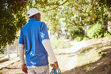 Image showing Outdoor animal shelter, cleaning and worker with hose walking in nature to clean for volunteer work. Community, charity and black man working at rescue center for dogs, animals and adoption of pets