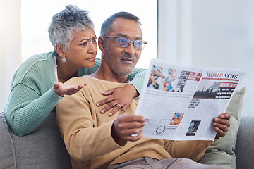 Image showing Senior couple, shocked and surprised by news while reading newspaper on sofa in living room at home together. Old man and woman check media article with fake news or bad crisis headline in retirement