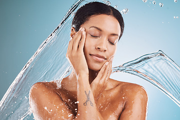 Image showing Woman, water splash or skincare cleaning on blue background in studio in healthcare wellness, self care or dermatology wellness. Beauty model, wet or drop motion in brazilian bathroom or relax shower