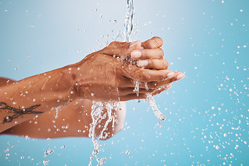 Image showing Water, washing and cleaning hands on blue background for hygiene, healthcare and cleansing in studio. Wellness, hydration and person washing hands for germ protection, bacteria and safety from virus