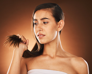 Image showing Hair, keratin and treatment with a model woman in studio on a brown background for damage or split ends. Salon, haircare and shampoo with a frustrated female suffering or annoyed with her hairstyle