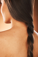 Image showing Hair, beauty and back of woman with braid for hair care, hair salon and luxury in orange background studio. Wellness, fashion and girl with healthy, natural and long hairstyle from keratin treatment