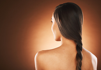 Image showing Woman, back or hair style on orange background in studio in keratin treatment marketing, balayage growth advertising or self care routine. Model, texture or healthy brunette color on aesthetic mockup