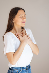 Image showing Woman with hands on chest doing breathing exercise at home